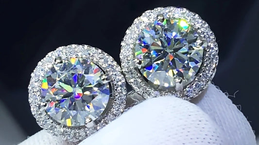 Pair of diamond stud earrings on a white stand with a dark background