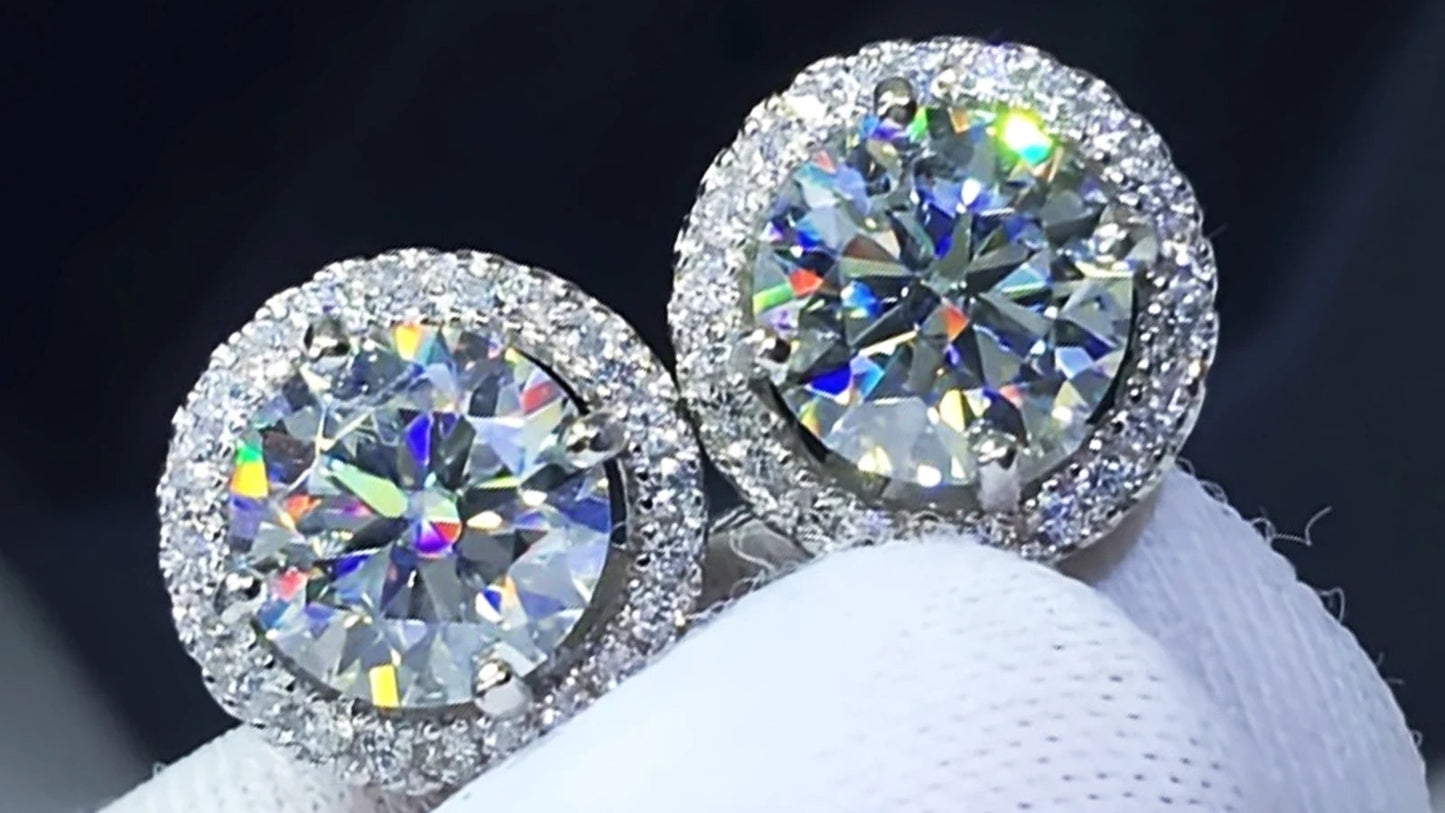 Pair of diamond stud earrings on a white stand with a dark background