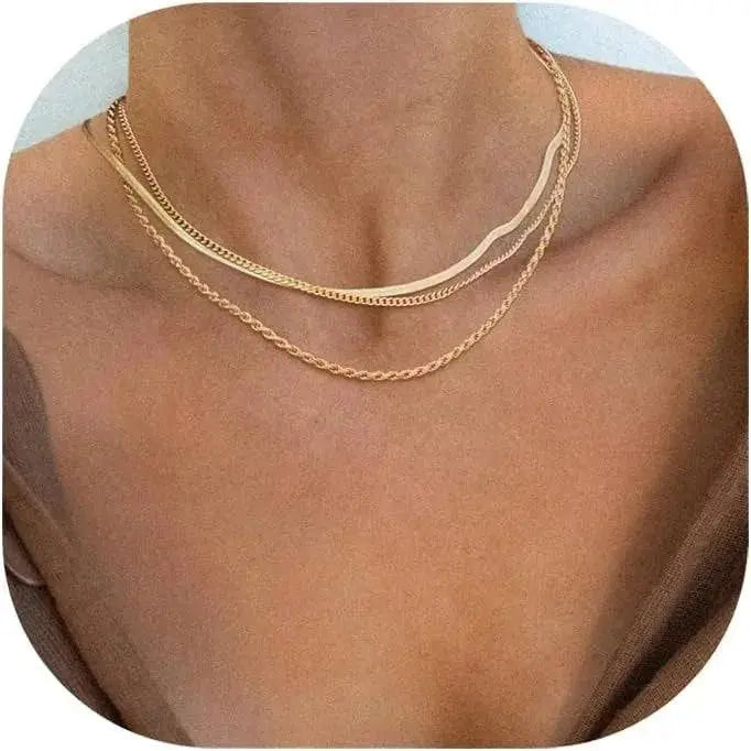 Gold plated snake chain necklace layered with gold chains on a woman's neck
